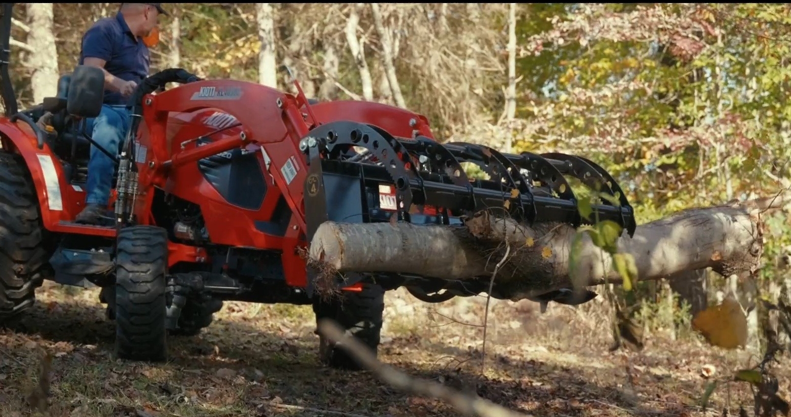 Compact Root Rake Grapple handling a log with compact tractor loader