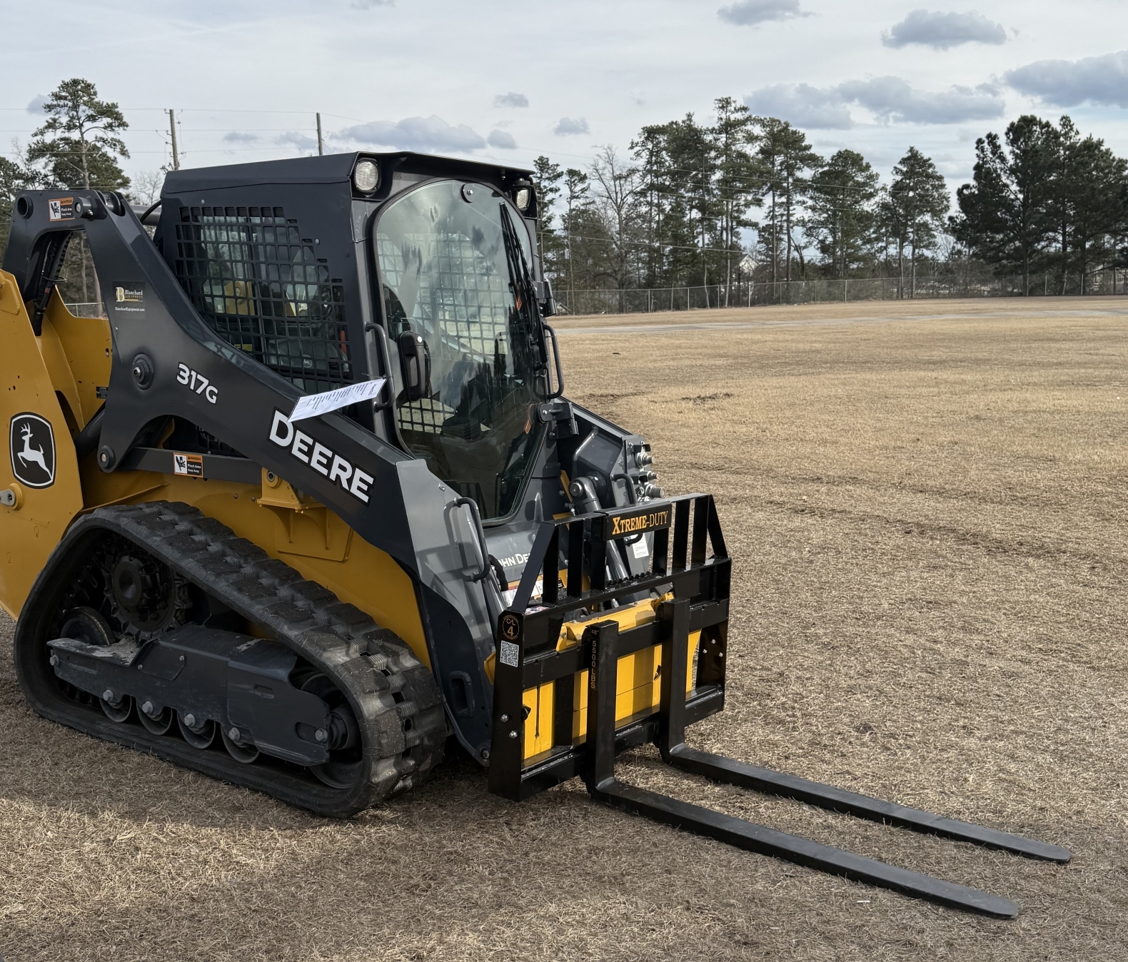 XTREME DUTY skid steer pallet forks mounted on a John Deere compact track loader
